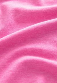 Tissu en coton rose, texture lisse avec une légère brillance, présentant de douces ondulations et des variations subtiles de l'intensité des couleurs.