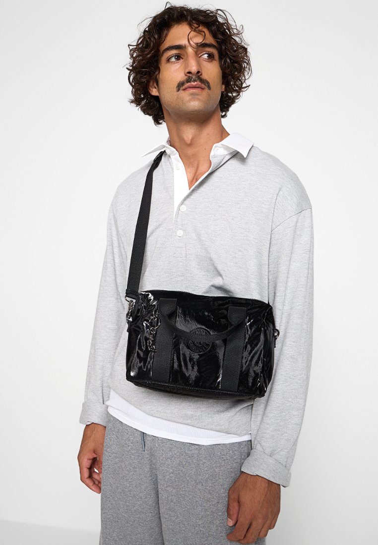 Borsa a spalla in pelle verniciata nera con doppi manici superiori, tracolla regolabile e dettaglio del logo sul fronte. Etichettata come design casual.