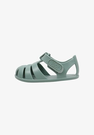 Sandalia de goma verde claro con puntera cerrada, correa ajustable de velcro y talón abierto.