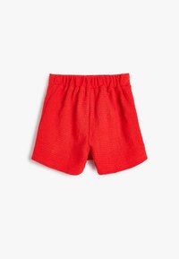 Rode geweven shorts met een elastische tailleband, met een gestructureerd oppervlak en twee zijzakken. Casual ontwerp geschikt voor warm weer.