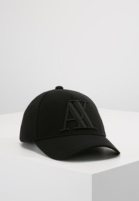 Casquette de baseball noire en tissu lisse, avec un logo "AX" noir en relief à l'avant et une visière incurvée.