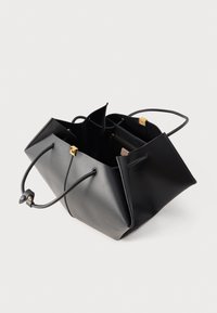 Borsa tote in pelle nera con due manici, apertura superiore e tasca interna con cerniera con etichetta visibile all'interno.
