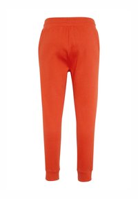 Orange Sweatpants mit einer weichen Textur, elastischem Bund und eng anliegenden Bündchen. Entworfen für Komfort mit einer klassischen, schmal zulaufenden Form.