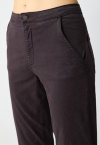Donkergrijze katoenen broek in een rechte snit, met zijzakken en een enkele knoopsluiting in de taille. Glad textuur.