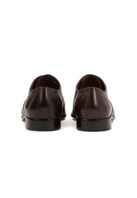 Bruine leren schoenen met een gladde afwerking, ronde neus en decoratieve brogue-details aan de zijkanten, met een lage, zwarte hak.