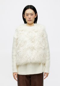 Suéter branco fofinho com uma frente texturizada e despenteada, mangas compridas e uma parte inferior canelada. Material de malha macia e grossa.