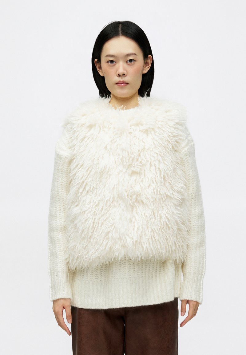 Suéter branco fofinho com uma frente texturizada e despenteada, mangas compridas e uma parte inferior canelada. Material de malha macia e grossa.