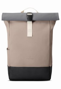 Batoh s rolovacím uzávěrem vyrobený z odolného béžového materiálu s šedým klopou. Má černé dno, bílý popruh a boční kapsu s minimalistickým logem.