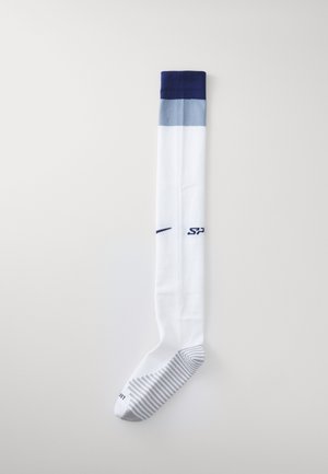 Chaussettes blanches montantes avec un dégradé de rayures bleues en haut, comportant des motifs rayés texturés gris et blancs sur la semelle.