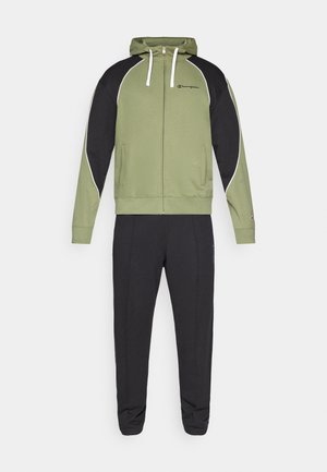 Ensemble de survêtement vert et noir comprenant une veste à capuche zippée et un pantalon fuselé, fabriqué en tissu doux avec des accents contrastés et un logo.