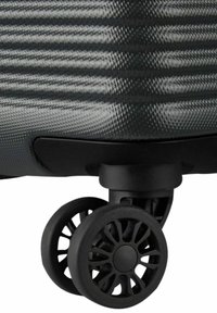 Valigia nera con ruote, caratterizzata da una superficie testurizzata. Presenta un corpo resistente e un design a doppia ruota per una mobilità fluida.