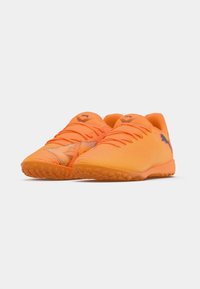 Orangefarbene Sportschuhe mit strukturiertem, synthetischem Obermaterial, Schnürverschluss und Gummisohle mit kleinen abgerundeten Noppen für besseren Halt.