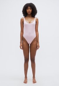 Ροζ ολόσωμο μαγιό με στρογγυλή λαιμόκοψη και λεπτές τιράντες. Διαθέτει λεία υφή και λεπτομέρεια με λογότυπο στο εμπρός μέρος.