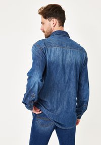 Jeanshemd in dunkelblauer Farbe, mit langen Ärmeln und geknöpften Manschetten, klassischem Kragen und geradem Rückendesign.