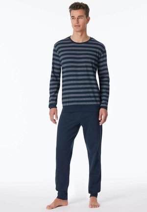 Haut à manches longues rayé bleu marine et gris avec des poignets côtelés, associé à un pantalon de lounge uni bleu marine. Tissu lisse avec une coupe décontractée.