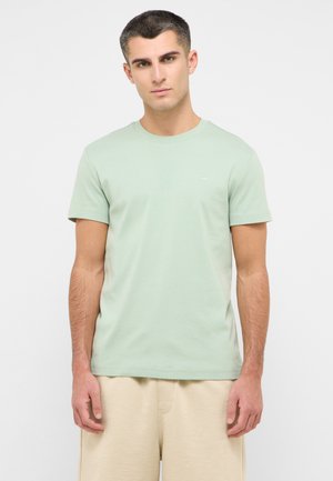 Hellgrünes T-Shirt mit kurzen Ärmeln aus einem Baumwollmix, mit Rundhalsausschnitt und einem kleinen Logo auf der Brust. Glatte Textur.