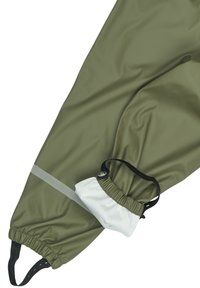 Pantalones impermeables de color verde oliva con puños elásticos, una franja reflectante y un bolsillo con cordón en tela blanca. Textura lisa y brillante.