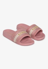 Chanclas rosas con una tira ancha con rayas blancas y rosas y el logo "SUPERDRY" en dorado. Fabricadas con material suave y duradero.
