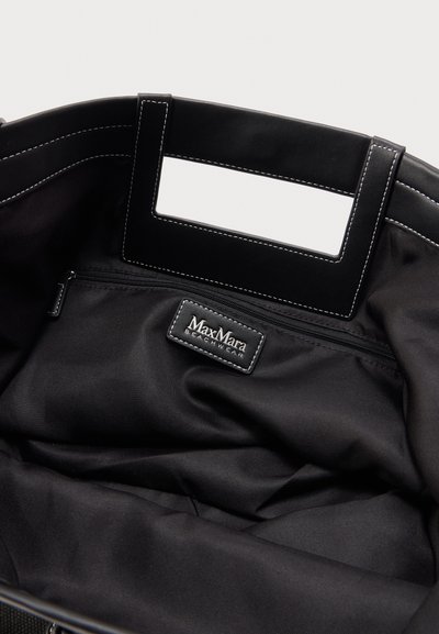 Εσωτερικό μαύρης τσάντας tote με θήκη με φερμουάρ και ραμμένη ορθογώνια χειρολαβή, με ετικέτα Max Mara Beachwear.