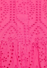 Fuchsia katoenstof met geborduurde uitsnijdingen en bloemmotieven, voorzien van een gestructureerde afwerking en geplooide zoom.