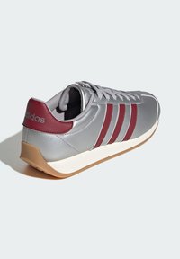 Silver sneaker with maroon accents and three stripes, featuring a smooth leather upper, rounded toe, and white midsole with a tan outsole.