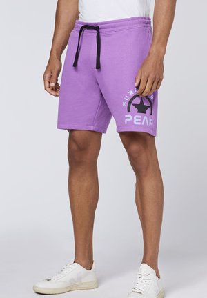 Purple sweat shorts with a drawstring waist, featuring a black star logo and text on the side. Made from a soft, textured material.