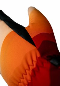 Textilhandschuh mit einem orange-roten Farbverlauf und einem schwarzen Riemen, glatte Oberfläche und Zickzacknaht auf der Seite.