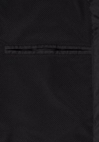 Tissu en maille noir avec une texture lisse et un détail de poche cousue horizontalement, offrant un espace de rangement fonctionnel.