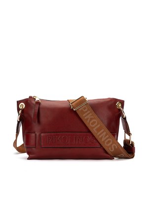Bolso bandolera de cuero rojo oscuro con correa marrón ajustable grabada con "PIKOLINOS" y detalles de herrajes metálicos en tono dorado.