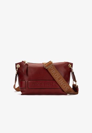 Bolso bandolera de cuero rojo oscuro con correa marrón ajustable grabada con "PIKOLINOS" y detalles de herrajes metálicos en tono dorado.