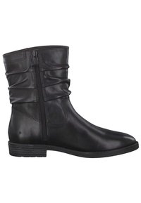 Svart läder ankelboot med volangdesign, sidodragkedja, rund tå och låg klack. Slät yta med subtila sömdetaljer.