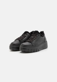 Sorte lær sneakers med en teksturert ullfòr, runde tå, snøring og en tykk, ribbet såle for ekstra høyd.