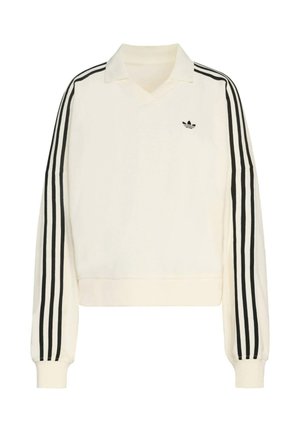 Kremasti pulover s V-izrezom, dugim rukavima, crnim prugama duž ruku i malim crnim logom na prsima. Izrađen od mekog materijala.