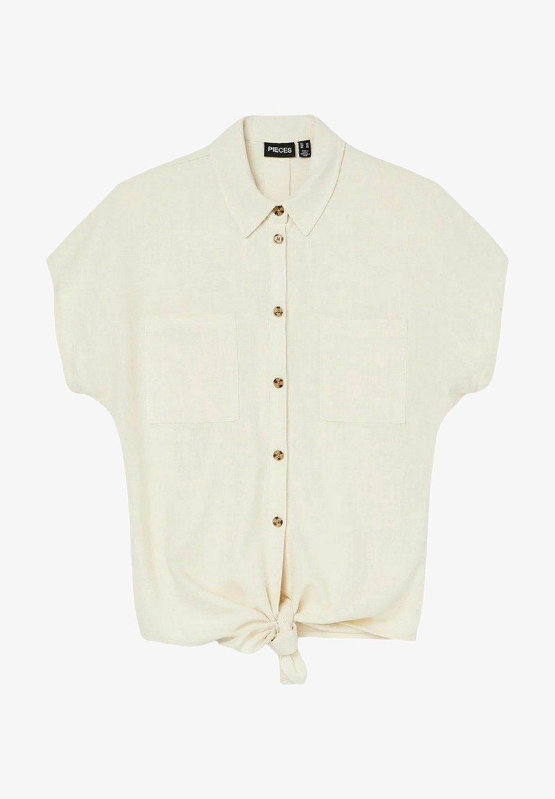 Short-sleeve beige shirt with a button-up front, two chest pockets, and a knotted hem detail. Made from lightweight, textured fabric.