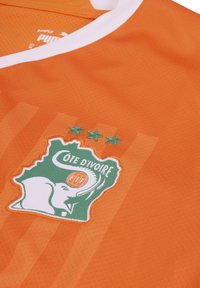 Maglia sportiva arancione realizzata in materiale traspirante, con un colletto bianco e un distintivo ricamato della Costa d'Avorio con tre stelle sopra.