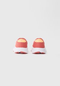 Un paio di scarpe da corsa rosa corallo con suole bianche, viste da dietro, etichettate "GEL-EXCITE 11" sui talloni.