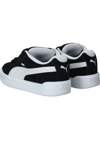 Sneaker in suede nero con dettagli bianchi, caratterizzate da un design a collo basso, suola in gomma bianca spessa e logo PUMA sul lato e sul tallone.