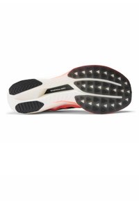 Suola di una scarpa da corsa con suola in gomma bianca e nera, testurizzata per la presa, con una zona accentuata in rosso e la scritta "ENERGY ARC".