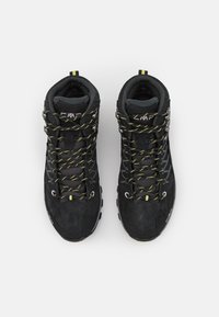 Scarpe da trekking nere con tomaia in mesh e suede, lacci gialli e neri, colletto imbottito e suola in gomma testurizzata per una buona aderenza.