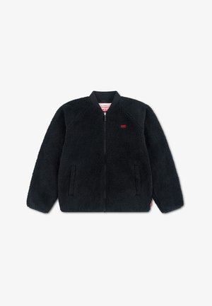 Veste polaire noire zippée avec poches latérales et petit logo rouge Levi's sur la poitrine, présentée sur fond blanc.