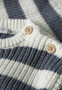 Maglione lavorato a maglia con strisce orizzontali blu navy e crema. Tessuto strutturato con bottoni di legno al collo.