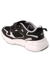 Czarnobiałe buty sportowe z siateczkową cholewką, dwiema rzepami, wyściełaną podeszwą i teksturowanym tyłem z logo.