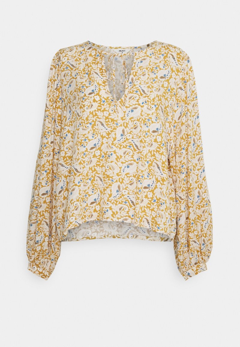 Gelbe Bluse mit floralen Mustern, langen Ballonärmeln, V-Ausschnitt und aufwendigen Paisleymustern in Blau- und Weißtönen. Leichter, strukturierter Stoff.