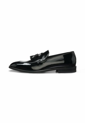 Sort blank læder tassel loafer med lav hæl og rundet tå, vist fra siden på hvid baggrund.