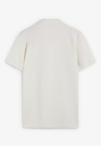 Camisa polo blanca de manga corta mostrada desde la parte de atrás, con un cuello clásico y sin logotipos o diseños visibles.