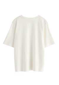 Hvid kortærmet t-shirt med rund halsudskæring og afslappet pasform. Glat tekstur med subtile sømme og et minimalistisk design.