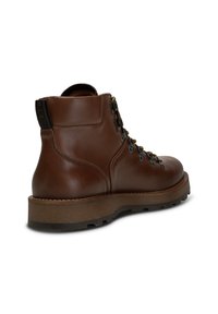 Stivale alla caviglia in pelle marrone con punta arrotondata, occhielli in metallo e suola in gomma texturizzata. Presenta una linguetta nera sul retro.