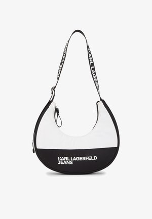 Torbica za ramo izdelana iz gladkega belega in črnega materiala, z obliko polmeseca, nastavljivim trakom z blagovno znamko in zgornjim zadrgo.