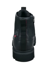 Botín negro de ante hasta el tobillo con un tacón de cuero texturado, detalles rojos y una cremallera lateral. Suela de goma con patrón acanalado para mayor tracción.