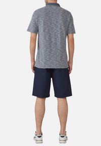 Granatowa i szara melanzowa koszulka polo z kołnierzykiem, zestawiona z granatowymi szortami i szarymi trampkami. Materiał ma subtelną teksturę.